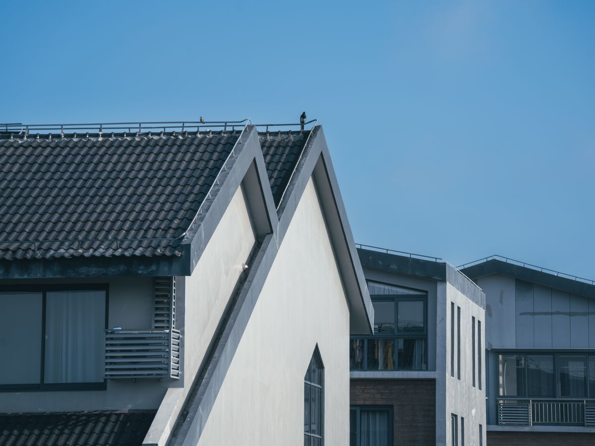 Clean residential roofline with seamless gutters against a blue sky